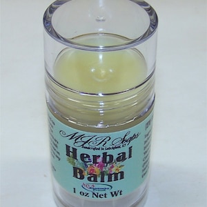 May include: A clear plastic container with a light yellow balm inside. The label reads "MJR Soaps Handcrafted in Leitchfield, KY Herbal Balm 1 oz Net Wt".
