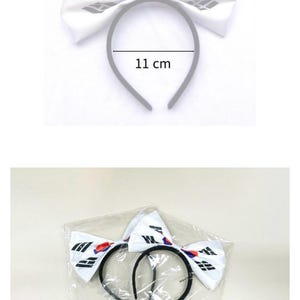 May include: White headband with a large bow featuring a design with the South Korean flag. The bow measures 22 cm wide, and the headband is 11 cm across. The headband is packaged in a clear plastic bag.