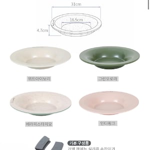 Puede incluir: Un juego de cuatro sartenes redondas y poco profundas en marfil, verde, pistacho y rosa. Cada sart&eacute;n mide aproximadamente 31 cm de di&aacute;metro y 4,7 cm de profundidad. La imagen tambi&eacute;n muestra un diagrama de las dimensiones y dos fundas de silicona gris.
