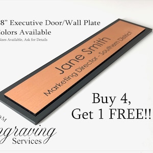 Puede incluir: Una placa ejecutiva para puerta o pared de 5,1 cm x 20,3 cm con acabado en cobre y borde negro. La placa tiene el nombre "Jane Smith" grabado, junto con el título "Directora de Marketing - Distrito Sur". La placa está disponible en 17 colores y en tamaños personalizados. El texto "¡Compra 4, llévate 1 GRATIS!!" también es visible en la imagen.