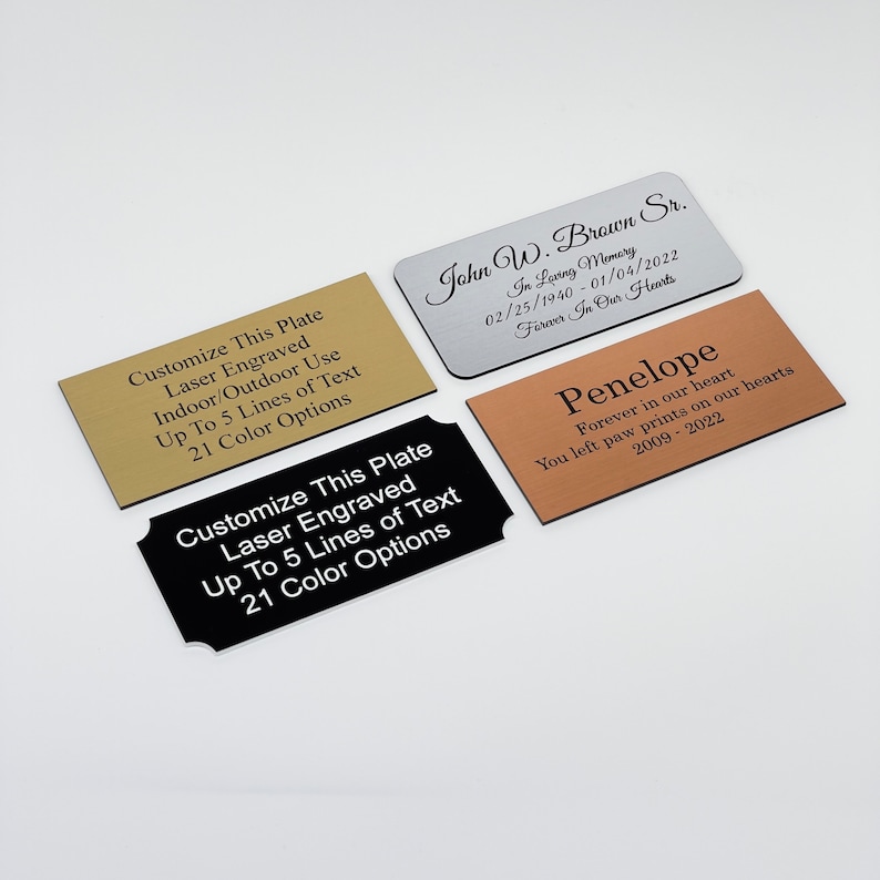 May include: Four different engraved metal plates with black text. The plates are gold, silver, black, and copper. The text on the plates reads: "Customize This Plate Laser Engraved Indoor/Outdoor Use Up To 5 Lines of Text 21 Color Options", "John W. Brown Sr. In Loving Memory 02/25/1940-01/04/2022 Forever In Our Hearts", "Customize This Plate Laser Engraved Up To 5 Lines of Text 21 Color Options", and "Penelope Forever in our heart You left paw prints on our hearts 2009-2022".
