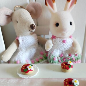 May include: A white ceramic mug with a black handle and the text "But First, Coffee" in a bold, black font. The mug is filled with a dark liquid, likely coffee, and sits on a light-colored surface.