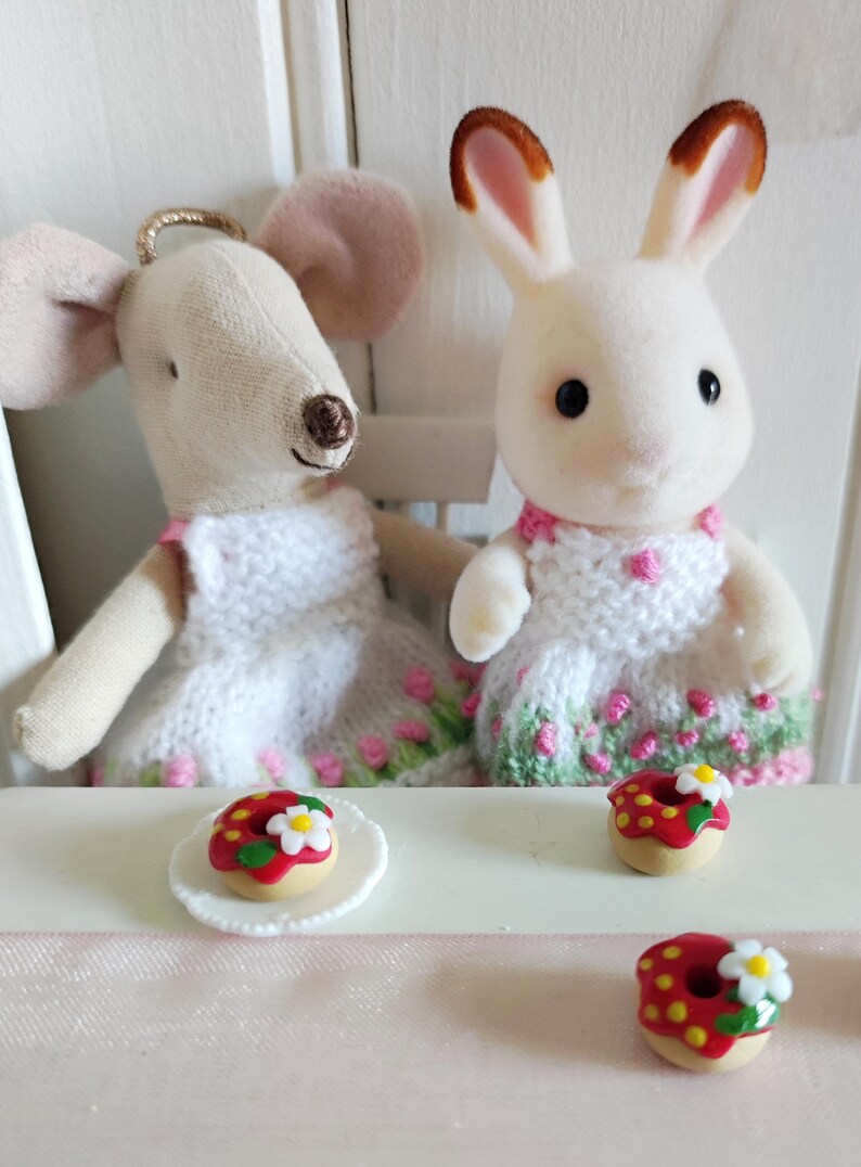 May include: A white ceramic mug with a black handle and the text "But First, Coffee" in a bold, black font. The mug is filled with a dark liquid, likely coffee, and sits on a light-colored surface.