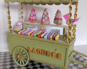 A very pretty miniature trolley completely filled with tiered cakes, macarons, boxes, Ladurée sachets, etc., for dolls