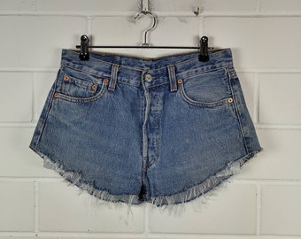 May include: Light blue denim shorts with a frayed hem. The shorts have a button and zipper closure and five pockets.