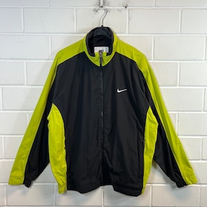 May include: Black and lime green windbreaker jacket with a zip fastening and a white Nike swoosh logo on the left chest.