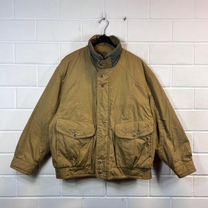 May include: A brown bomber jacket with a snap closure and two flap pockets. The jacket has a green lining.