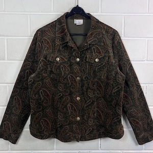 Könnte beinhalten: Eine langärmelige Jacke mit Knopfleiste in einem dunkelolivgrünen und braunen Paisle und braunen Paisley-Muster. Die Jacke verfügt über einen klassischen Kragen, zwei Brusttaschen mit Knopfverschluss und eine durchgehende Knopfleiste mit Metallknöpfen.