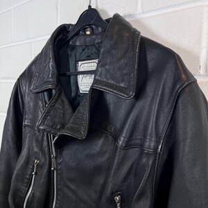 May include: Black leather jacket with a classic asymmetrical zipper design. The jacket features a wide collar, multiple pockets, and a label that reads "Jorg". The jacket is hanging on a black hanger.