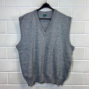 May include: A gray sleeveless sweater with a v-neck. The sweater is made of a soft, knitted fabric.