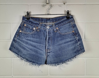 May include: A pair of blue denim shorts with a frayed hem. The shorts have a high waist and five pockets.