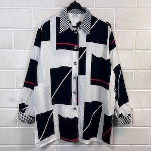 Blusa feminina vintage dos anos 90, preta, branca e vermelha, em viscose, com estampa gráfica e gola xadrez. Tamanhos G e GG.