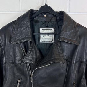 May include: Black leather jacket with a notched collar and a zipper closure. The jacket has a label that reads "Giorgio" and "A Delta Leather Product, Perfected and Developed, London."