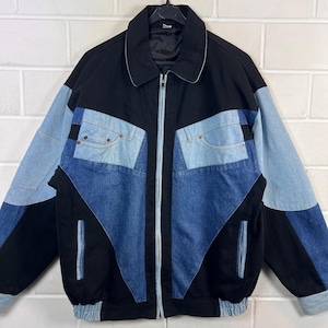 Puede incluir: Chaqueta vaquera vintage con un diseño patchwork único. La chaqueta presenta un cuerpo negro con paneles de mezclilla azul claro y oscuro, incluyendo detalles de bolsillo. Tiene una cremallera y un cuello clásico.