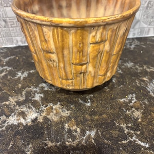 Peut inclure: Un bol en céramique avec un motif texturé en forme de tissage. Le bol est d'une couleur chaude et terreuse avec des lignes verticales et horizontales, créant un aspect tissé. L'intérieur est d'une couleur plus claire et crémeuse. Le bol est probablement à usage décoratif ou fonctionnel.