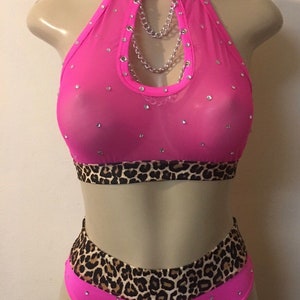 May include: Pink mesh halter top with a leopard print trim and a silver chain detail. The top is adorned with rhinestones. Matching pink mesh bottoms with a leopard print trim and rhinestones.