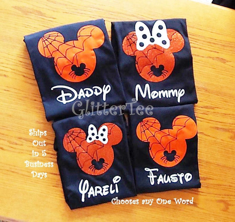 May include: Four black t-shirts with a spiderweb Mickey Mouse design. The shirts have the words "Daddy", "Mommy", "FAUSTO", and "PARELI" printed on them.
