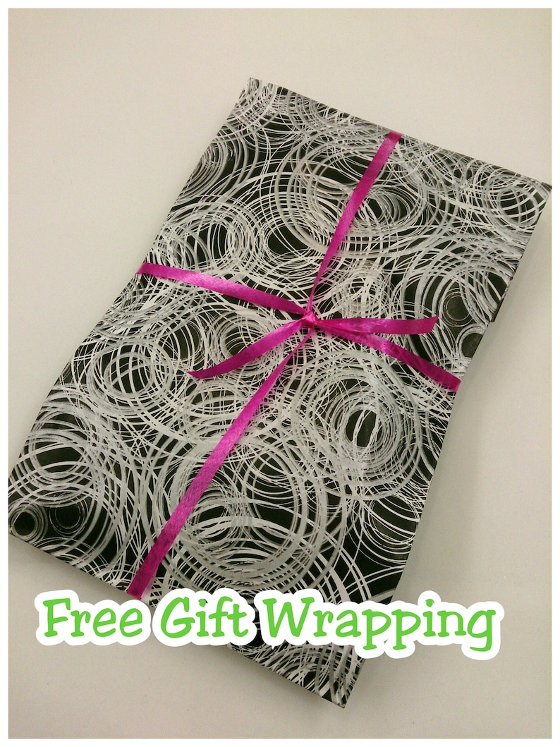 May include: Black and white gift wrapping paper with a swirling pattern. A pink ribbon is tied around the paper. The text "Free Gift Wrapping" is printed on the paper.