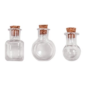 May include: Three clear glass bottles with cork stoppers. The first bottle is square-shaped, the second is round with a flat base, and the third is a small bulbous vial. Each bottle features a narrow neck and a natural brown cork plug.