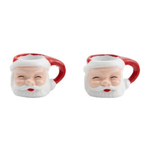 May include: Two ceramic mugs shaped like Santa Claus. Each mug features a white face with a red nose and mouth, a white beard, and a red hat and handle. The mugs are designed for holiday use.