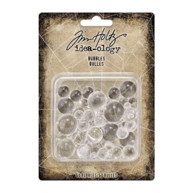 May include: A package of clear plastic bubbles, labeled "Bubbles Bulles" by Tim Holtz Idea-Ology.