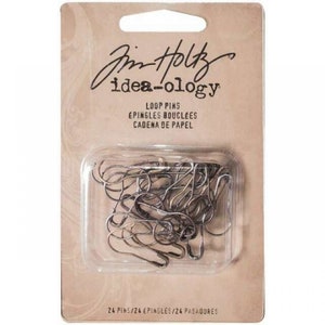 May include: A package of 24 silver loop pins for crafting. The package is labeled "Jim Holtz idea-ology Loop Pins, Epingles Bouclees, Cadena de Papel".