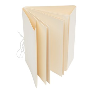 May include: A white blank book with a string closure. The book is open and the pages are fanned out.