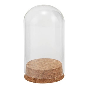 May include: A clear glass dome with a cork base. The dome is round and has a smooth surface. The base is made of cork and has a natural brown color.