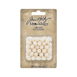 May include: A package of 50 white plastic tiny eggs, labeled "Jim Holtz idea-ology Tiny Eggs Petits Oeufs".