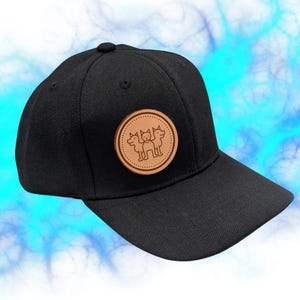 May include: Black baseball cap with a brown leather patch featuring a three-headed dog design.