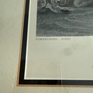 Puede incluir: Obra de arte en blanco y negro enmarcada con el texto "DOMENICHINO, PINXT". La obra es un grabado detallado, que presenta una escena cl&aacute;sica. El marco es negro con un borde interior dorado, sobre un passe-partout crema.