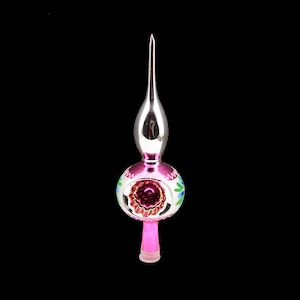 Könnte beinhalten: Ein Vintage-Weihnachtsbaumspitze mit einer silbernen Spitze und einer rosa, runden Basis. Die Basis ist mit kleinen blauen und grünen Blumenmustern verziert. Der untere Stiel ist rosa mit einer transparenten Kunststoffbasis.