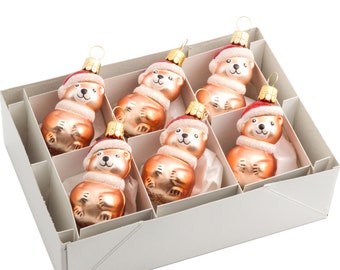 May include: A set of six glass Christmas ornaments in a white box. Each ornament is shaped like a bear wearing a red Santa hat and a white fur trim. The bears are a light brown color.