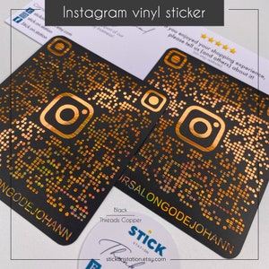 Può includere: Due adesivi in ​​vinile nero con un logo Instagram dorato e un codice QR. Gli adesivi sono su uno sfondo bianco con un adesivo che dice "Stick Station" e il testo "Black Threads Copper".