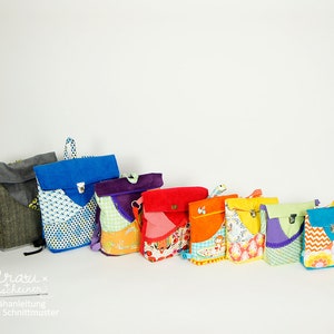 Könnte beinhalten: Ein Set aus neun bunten Mini-Rucksäcken in verschiedenen Mustern und Stoffen. Die Rucksäcke reichen von klein bis groß und sind in Regenbogenreihenfolge von links nach rechts angeordnet. Die Rucksäcke bestehen aus verschiedenen Materialien, darunter Filz, Cord und Baumwolle.