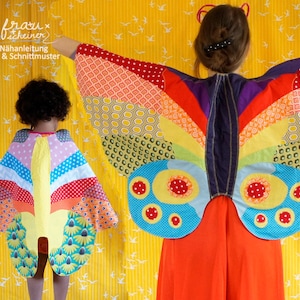 Könnte beinhalten: Zwei Personen tragen farbenfrohe Schmetterlingsflügel aus Stoffresten. Die Flügel sind im Patchwork-Stil mit verschiedenen Mustern und Farben zusammengenäht. Die Flügel sind groß und dramatisch, und die Personen lächeln und sehen glücklich aus.