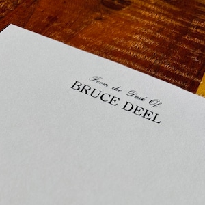 May include: White stationery with the text "From the Desk of BRUCE DEEL" printed in black ink.