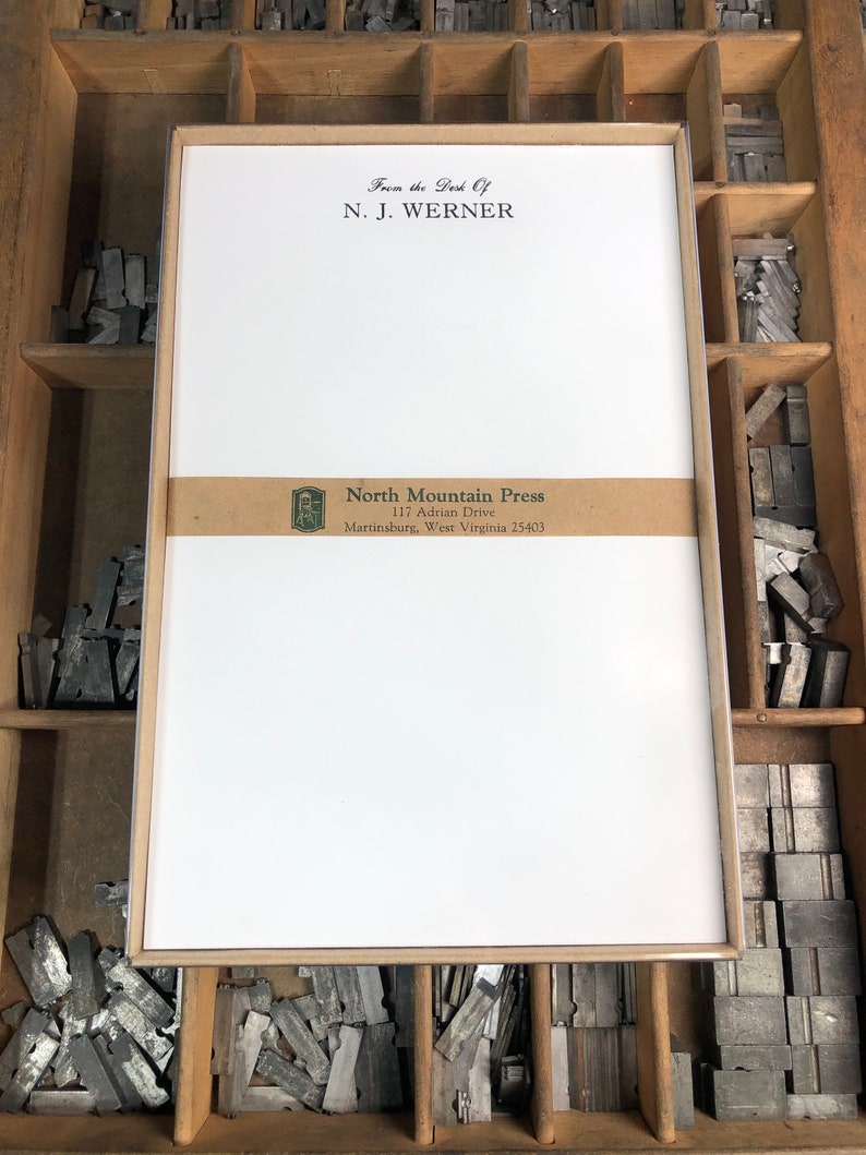 May include: A white card with a brown border and a brown label with the text "North Mountain Press, 117 Adrian Drive, Martinsburg, West Virginia 25403". The card also has the text "From the Desk Of, N. J. Werner" at the top.