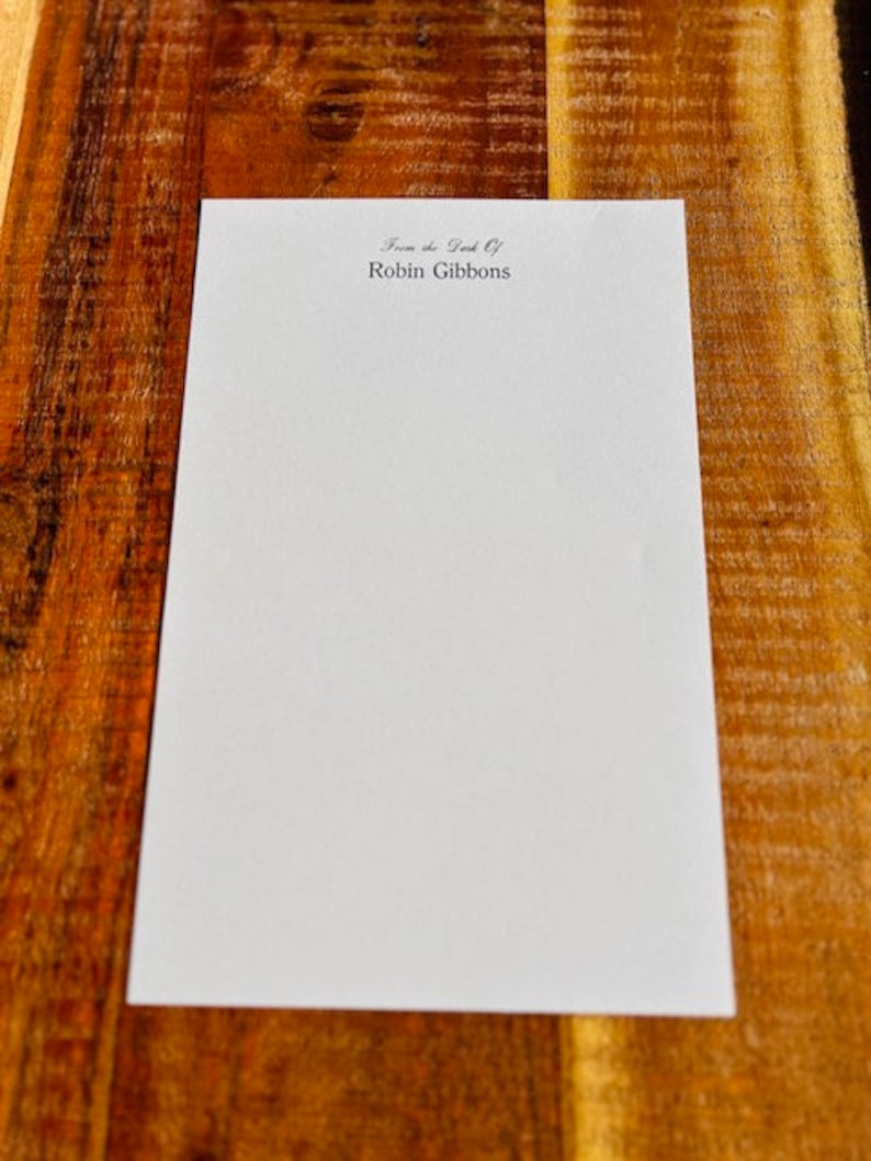 May include: A white sheet of paper with the text "From the Desk Of Robin Gibbons" printed at the top.