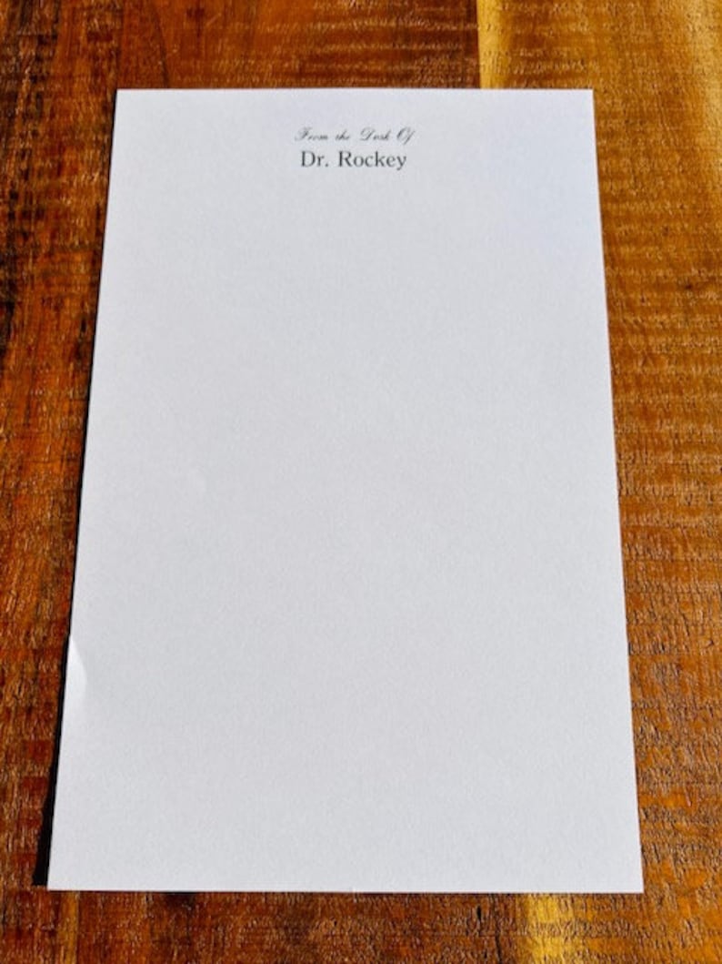 May include: A blank white sheet of paper with the text "From the Desk Of Dr. Rockey" printed at the top.