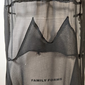 May include: Black sheer fabric with a black triangle shape sewn into the fabric. The fabric has a textured, woven look. The text "FAMILY FORMS 2" is visible at the bottom of the image.