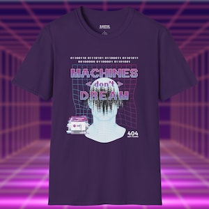 Peut inclure: Un t-shirt violet avec le texte "MACHINES don't DREAM" dans une police rétro. Le t-shirt présente un graphique d'une tête numérique et d'une voiture, avec un code binaire au-dessus. Le texte "404 NOT FOUND" est également présent.