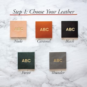 May include: Five leather swatches in different colors: nude, caramel, black, forest green, and gray. Each swatch has the letters "ABC" embossed in gold.