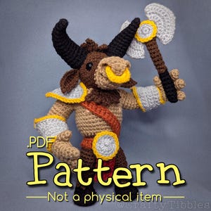 May include: A handmade crochet bull warrior doll, featuring black horns, a yellow nose ring, and a brown and tan body. The doll is holding a gray and brown axe and wears armor with yellow accents. The image includes the text "PDF Pattern - Not a physical item".