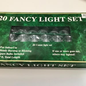 May include: A green box with the text "20 FANCY LIGHT SET" contains a set of 20 clear light bulbs. The box also states "For Indoor Use", "Steady Burning or Blinking", and "17 ft. Total Length".
