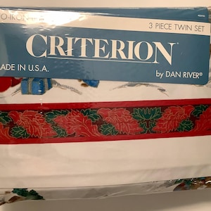 May include: A white twin-sized 3-piece bedding set with a red and green holiday border. The packaging features the words "Criterion" and "by Dan River".