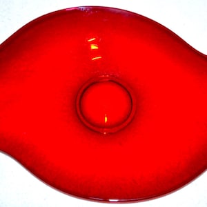 Può includere: Una ciotola di vetro rosso con un bordo ondulato e una ciotola rotonda più piccola al centro.