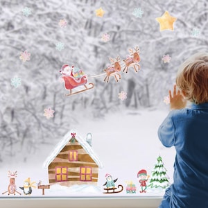 Peut inclure: Un enfant regarde par une fenêtre décorée d'autocollants de Noël. Les autocollants représentent le Père Noël dans son traîneau tiré par des rennes, une cabane recouverte de neige, des pingouins, un bonhomme de neige et un sapin de Noël. Il y a aussi des flocons de neige et des étoiles éparpillés sur la fenêtre.
