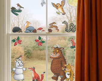 May include: A window decorated with colorful cartoon stickers of forest animals and plants. The scene includes an owl, snake, fox, mouse, and a snowman. A brown curtain is on the right side of the window.