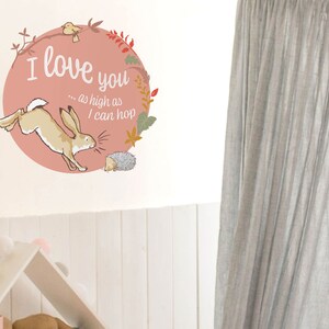 May include: A pink circle with a brown rabbit jumping and a hedgehog on the ground. The text "I love you... as high as I can hop" is written in black on the circle.
